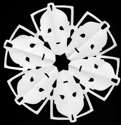 A paper snowflake cut to look like 6 Cybermen heads, their chins on the inside and their antennae on the outside.